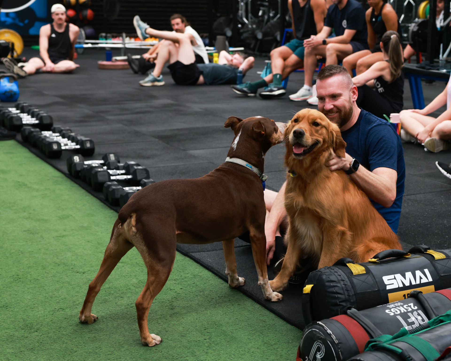 A member and two studio dogs hanging out on the floor after class at BFT Abbotsford